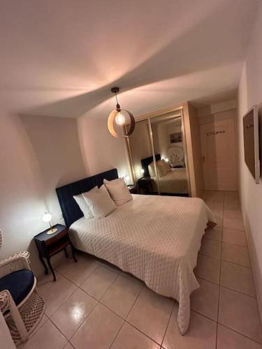 une chambre avec un lit et une chaise dedans dans l'établissement Nouveau cœur de ville, 100 m de la plage, spacieux, à Sainte-Maxime