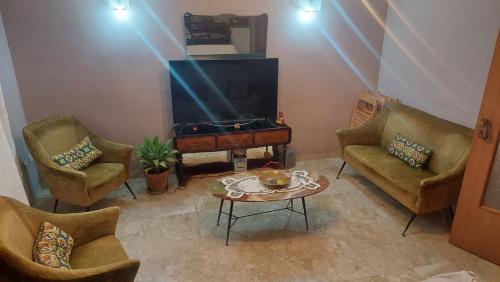 een woonkamer met een tv en 2 stoelen en een tafel bij Chi nnicchi e nnacchi in Noto