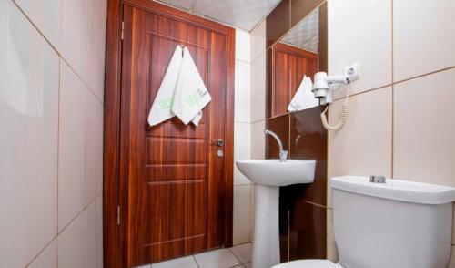 a bathroom with a toilet and a wooden door at Seyir Evleri DİVAN in Kayseri