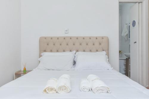 uma cama branca com duas toalhas brancas em Apartamento em ótima localização em São Paulo