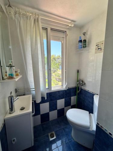 スカラ・フォルカスにあるMaria's Sea View Houseのバスルーム(トイレ、洗面台付)、窓が備わります。