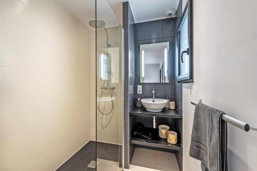 a bathroom with a sink and a glass shower at Villa de standing mer, proximité plage et thalasso in Douarnenez