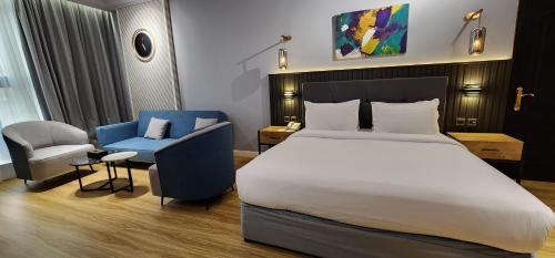 a bedroom with a large bed and a blue chair at Qasr Al Sahab in Khamis Mushayt