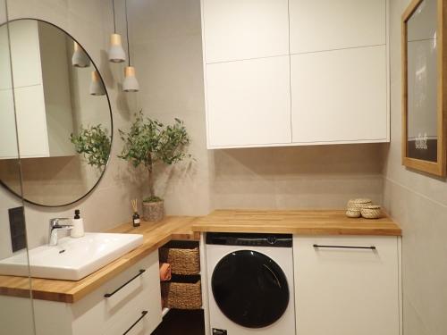 een keuken met een wastafel en een wasmachine bij Apartament Narutowicza 56 in Łódź