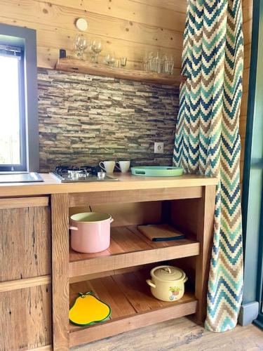 a kitchen with a wooden shelf with dishes on it at Country House in Vadu Crişului