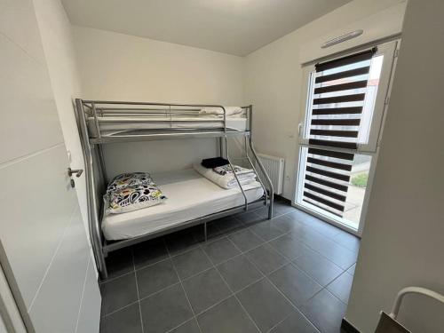 a bunk bed in a room with a window at Super appartement, la Guérinière à Noirmoutier in La Guérinière