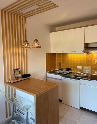 une cuisine avec des armoires blanches et un comptoir en bois dans l'établissement Andernos Beach Studio, à Andernos-les-Bains