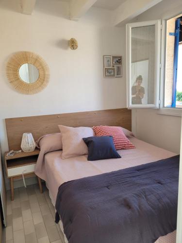 une chambre avec un grand lit avec un miroir dans l'établissement La plagette d'emy, au Cap d'Agde