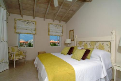 um quarto com uma cama grande e um cobertor amarelo em Sunny Vacation Villa No 13 em Saint James
