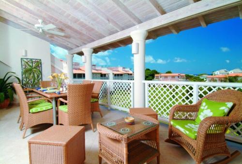 um pátio com uma mesa e cadeiras numa varanda em Sunny Vacation Villa No 13 em Saint James