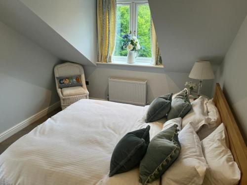 1 dormitorio con 1 cama grande con almohadas y ventana en The Croft, en Cowbridge