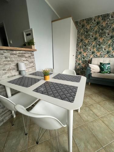 a white dining table and chairs in a living room at Apartament Słoneczny in Świnoujście
