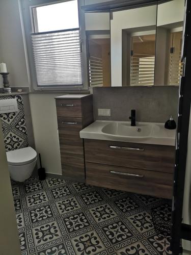 a bathroom with a sink and a toilet and a mirror at Zur Alten Schmiede mit Museum in Rüstungen