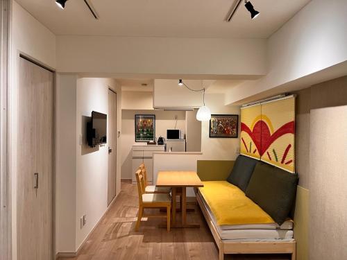 a living room with a table and a couch at 浅草寺3分 浅草駅6分 2寝室+リビング2-6人 スカイツリービュー 駅近 成田空港&羽田空港直通 in Tokyo