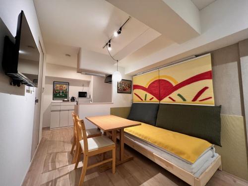 a small room with a dining table and a couch at 浅草寺3分 浅草駅6分 2寝室+リビング2-6人 スカイツリービュー 駅近 成田空港&羽田空港直通 in Tokyo