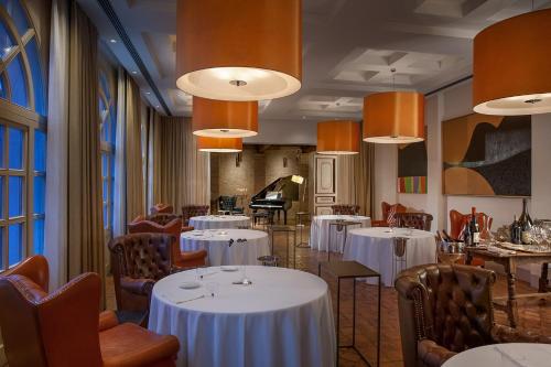 a dining room with white tables and chairs at Relais & Chateaux Palazzo Seneca in Norcia