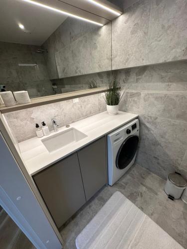 uma casa de banho com um lavatório e uma máquina de lavar roupa em Pärnu rannarajooni apartment em Pärnu