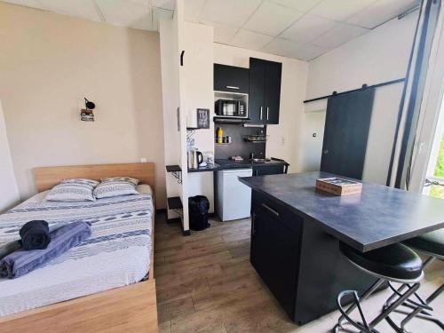 una piccola stanza con un letto e una scrivania di Studio Centre Ville Stadium a Agen