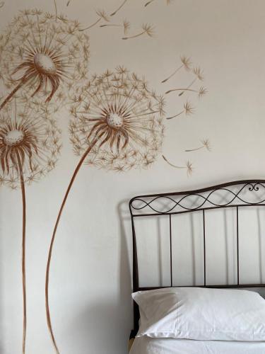 a bedroom with a dandelion mural on the wall at Novecento Charming Room in Avigliana