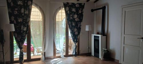 a room with two windows with curtains and a fireplace at Casetta di Laura in Pisa
