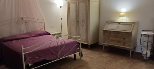 a bedroom with a purple bed and a dresser at Casetta di Laura in Pisa