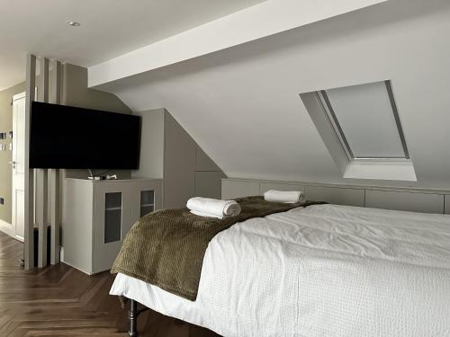 a bedroom with a bed and a flat screen tv at Super deluxe apartment in Barnet
