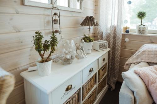 a white dresser with plants on it in a bedroom at Guest House Marjala in Kotka