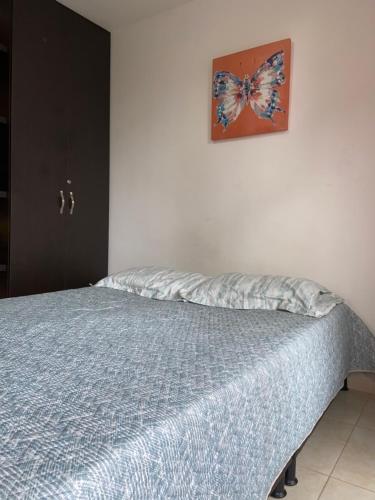 sypialnia z łóżkiem z motylem na ścianie w obiekcie Casa Roma - La tranquilidad del campo en la Ciudad - RNT 1 0 8 1 3 7- w mieście Salento