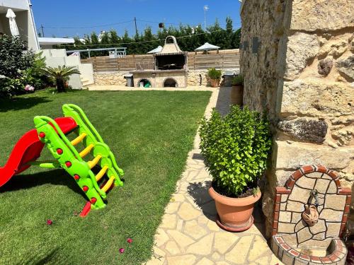 a playground with a green slide in a yard at BIO Garden Stonehouse in Gonia