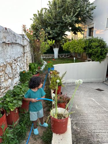 a young boy watering plants in a garden at BIO Garden Stonehouse in Gonia