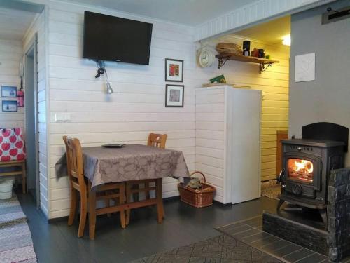 - une salle à manger avec une table et une cuisinière dans l'établissement Lysti Cottage by the lake and magical countryside, à Rovaniemi