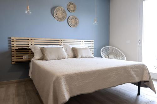 a bedroom with a large bed with a white blanket at Sunrise Sardinia Posada in Posada