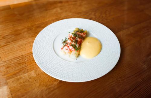 a white plate with food on a wooden table at Hostrups Hotel in Tønder