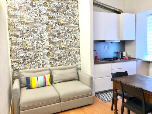 a living room with a couch in front of a wall at Casa Tre Gradini in Perugia