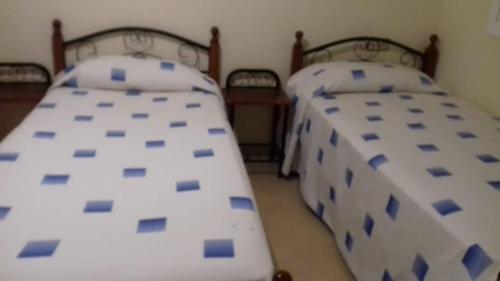 2 camas en una habitación con almohadas azules y blancas en إقامة للعطلة على بعد 200 متر من البحر, en Nador