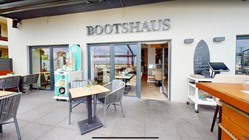 a restaurant with tables and chairs in front of a store at Seaside-Strandhotel in Timmendorfer Strand