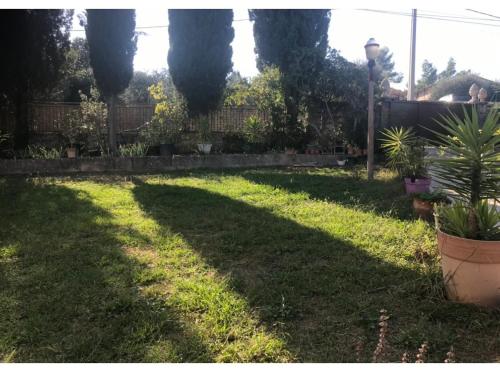 une cour avec une grande ombre sur l'herbe dans l'établissement Maryline, à Grasse