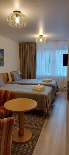 una camera d'albergo con due letti e un tavolo di Borena a Palanga