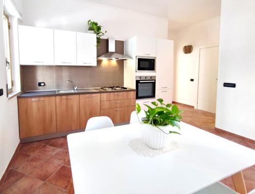 a kitchen with a white table with a plant on it at Villa singola Amanda - 500m dal mare in Pulsano