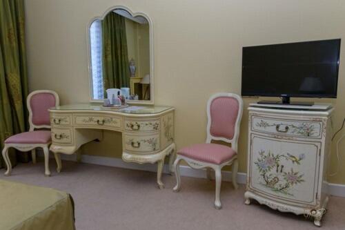 a bedroom with a desk with a tv and a mirror at Hôtel de la cloche in Vitry-le-François