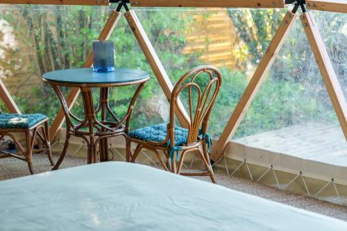 une table et des chaises dans une pièce avec une fenêtre dans l'établissement Dôme avec vue sur Loire proche de Chambord, à Saint-Dyé-sur-Loire