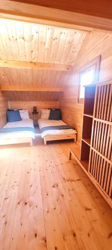 a room with two beds in a wooden cabin at Ostoja Struga in Świnoujście