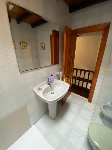 a bathroom with a sink and a mirror and a toilet at Casa Gin Tazones in Tazones