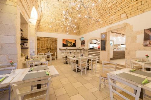 restauracja ze stołami i krzesłami w pokoju w obiekcie Trulli D'Angiò w Alberobello