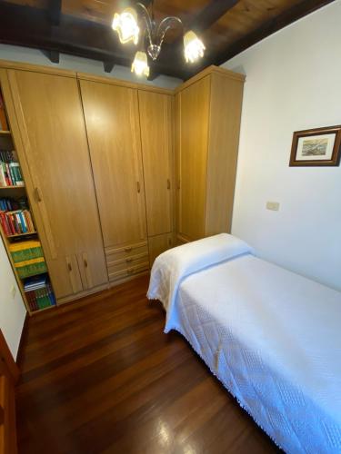 a bedroom with a bed and a book shelf at Casa Gin Tazones in Tazones