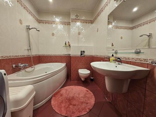 een badkamer met een bad, een wastafel en een toilet bij Apartament Rodzinny RETRO Górska Holdimex by RentiloPL in Szczyrk