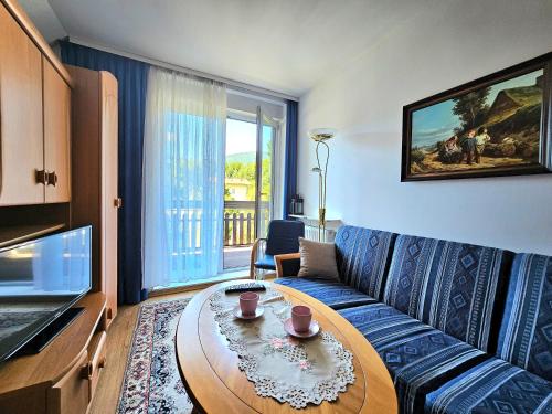 een woonkamer met een bank en een tafel bij Apartament Rodzinny RETRO Górska Holdimex by RentiloPL in Szczyrk