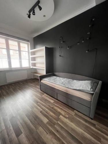 a bedroom with a bed and a wooden floor at Klimatyczne mieszkanie w krainie jezior in Biskupiec