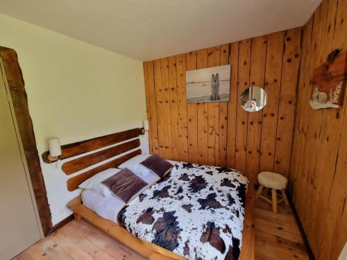 une chambre avec un lit et un mur en bois dans l'établissement Domaine de la Graou, à La Palud-sur-Verdon