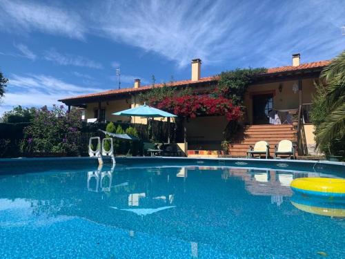 a villa with a swimming pool in front of a house at Casa Ángeles in Nueva de Llanes